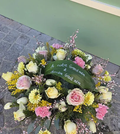 Couronne de fleurs jaunes et roses avec un ruban de message