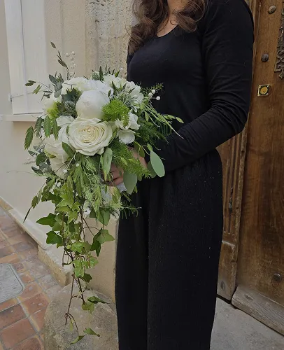 Bouquet tombant de roses blanches et de feuillage tenu à la main
