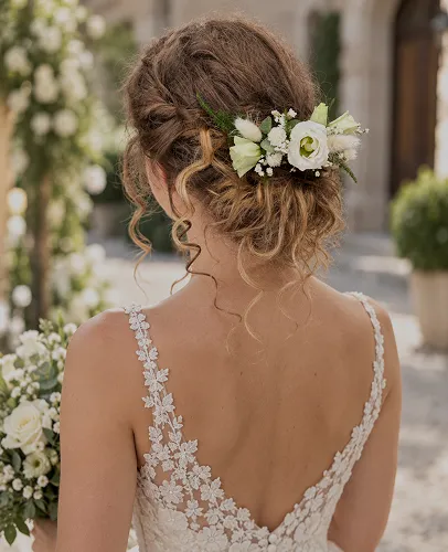 Fleurs blanches piquées dans le chignon d’une mariée