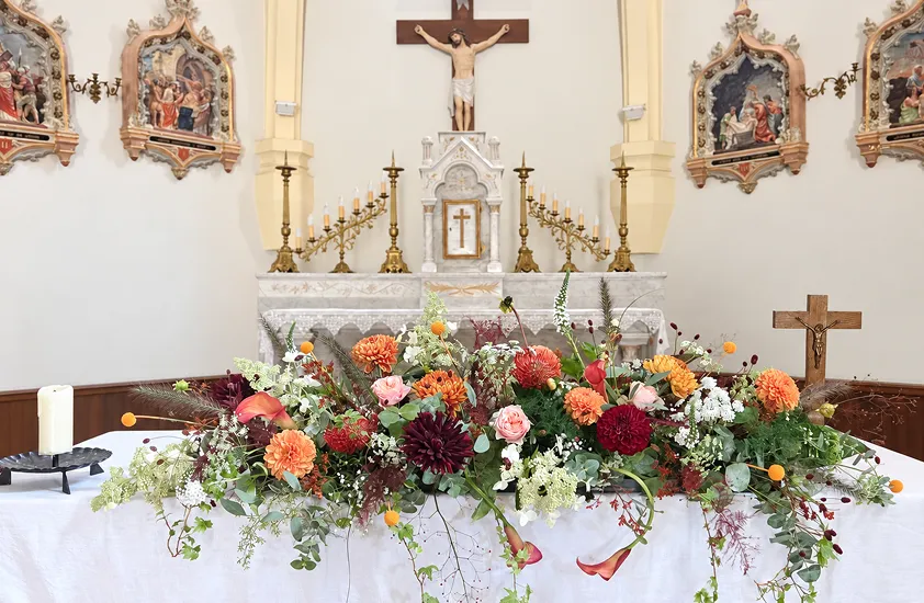 Composition florale colorée devant l’autel d’une église